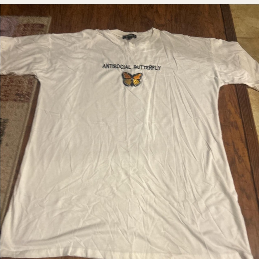 T-shirt with “ANTISOCIAL BUTTERFLY” on the front.